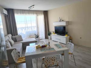 a living room with a couch and a table and chairs at Sunrise Luxury Sauth Bay in Varna City