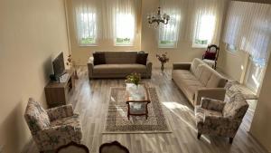 a living room with a couch and chairs and a tv at Paradise Villa Trabzon in Trabzon +39 photos