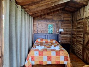 a bedroom with a bed in a log cabin at Hotel Mirador de Quetzales in Providencia