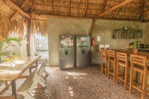 a kitchen with a refrigerator and a table and chairs at La Canasta in El Zonte
