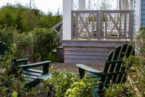 due sedie verdi sedute sul portico di una casa di Creekside Cottage by Seabrook Hospitality a Pacific Beach