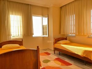 a bedroom with two beds and two windows at Paradise Villa Trabzon in Trabzon