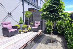 two chairs on a wooden deck in a garden at Apartment 4 - Haddin Court - Chic NY Loft Style in Blenheim