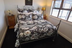 a bed with a black and white comforter and pillows at Apartment 4 - Haddin Court - Chic NY Loft Style in Blenheim