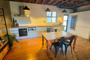 a kitchen with a wooden table and chairs in it at Apartment 4 - Haddin Court - Chic NY Loft Style in Blenheim +27 photos