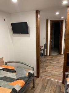 a bedroom with a bed and a flat screen tv on the wall at Ferienwohnung Funke F4 für Monteure in Apolda +3 photos