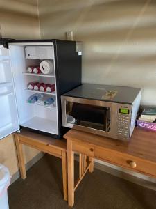 a microwave sitting on a table next to a refrigerator at Rawlins Western Lodge in Rawlins