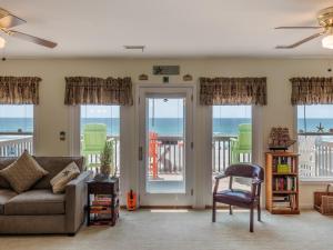 a living room with a couch and views of the ocean at Perse-vear-ance in Topsail Beach