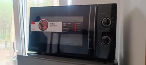 a microwave oven with a sticker on the front of it at Pine forest house 8 in Gauja