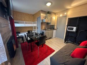 a living room with a table and a room with a bed at Le Chaleureux Cocon Rouge in Ustou
