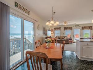 a kitchen and dining room with a table with a view of the ocean at Perse-vear-ance in Topsail Beach