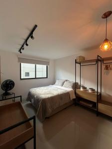 a bedroom with a bed and a window at Charmoso apartamento em Itaipava in Itaipava