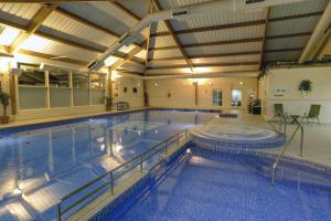 a large indoor swimming pool with a large swimming poolvisor at Best Western Kings Manor in Edinburgh