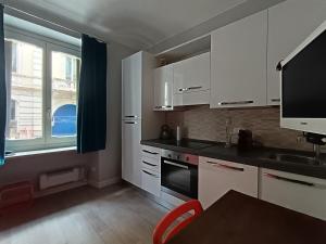 a kitchen with white cabinets and a sink and a window at Centralissimo grazioso monolocale in Turin