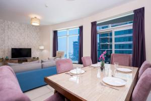 a living room with a table and a blue couch at Vacay Lettings - Loft Downtown Dubai in Dubai