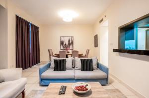 a living room with a couch and a table at Vacay Lettings - Loft Downtown Dubai in Dubai