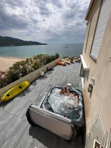 due persone in una vasca idromassaggio su un ponte vicino alla spiaggia di La Maison sur la Plage a Calcatoggio Altre 21 foto