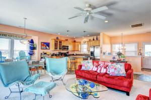 a living room with a red couch and blue chairs at Piccolo Paradiso in Topsail Beach