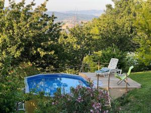 a deck with a chair and a swimming pool at La Bellana in Guardistallo