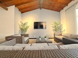 uma sala de estar com mobiliário em vime e uma televisão de ecrã plano em Beautiful and cozy house in the best location em Medellín