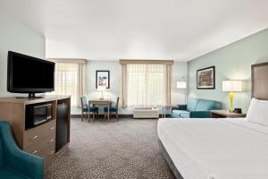 ein Hotelzimmer mit einem Bett und einem Flachbild-TV in der Unterkunft La Quinta by Wyndham Newport in Newport