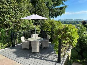 een tafel en stoelen met een parasol op een terras bij White Heather Terrace in Bovey Tracey