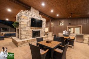 a living room with a stone fireplace with tables and a dog at Terracotta Bliss Wimberley Retreat For 28 Guests in Wimberley
