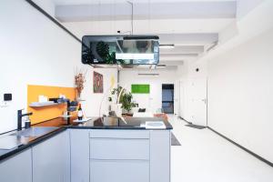 een keuken met een wastafel en een tv aan het plafond bij Design Family Apartment in Leiden Center 6p & baby in Leiden