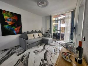 a living room with a couch and a painting on the wall at 2 Bedrooms Flat + Balcony + Parking at Las Canteras Beach in Las Palmas de Gran Canaria