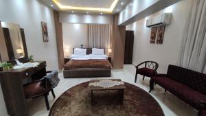 アスユートにあるفندق أجياد Agyad Hotelのベッドとリビングルームが備わるホテルルームです。
