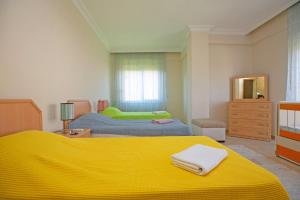 1 dormitorio con 2 camas y manta amarilla en Paradise Town Villa Hazel, en Belek 38 fotos más