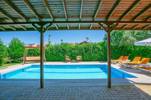 Una piscina bajo un pabellón con sillas y sombrilla. en Paradise Town Villa Hazel, en Belek