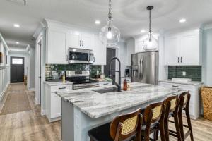 a kitchen with white cabinets and a marble counter top at Lincolnville Nook in St. Augustine