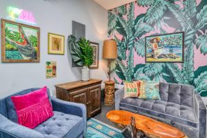 a living room with two couches and a tropical wallpaper at Lincolnville Nook in St. Augustine