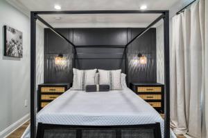 a bedroom with a black canopy bed with two night stands at Lincolnville Nook in St. Augustine