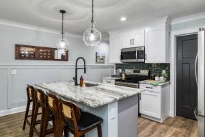a kitchen with white cabinets and a granite counter top at Lincolnville Nook in St. Augustine +42 photos
