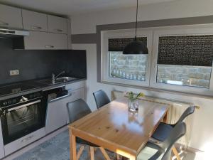 a kitchen with a wooden table and some chairs at Ferienhaus Schrammsteinblick in Altendorf