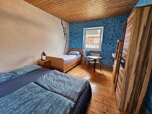 sypialnia z 2 łóżkami, stołem i krzesłem w obiekcie Idyllisches Ferienhaus im Fichtelgebirge w mieście Nagel