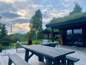 drewniany stół piknikowy i krzesła na patio w obiekcie Cosy and Quiet Cabin with Sauna close to Hemsedal w mieście Lykkja