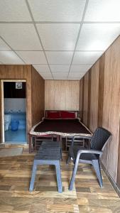 Zimmer mit einem Bett, einem Tisch und Stühlen in der Unterkunft Rishikesh Riverside Camping By PT in Rishikesh