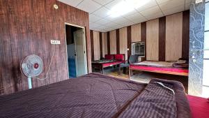 ein Schlafzimmer mit einem Bett und einem Ventilator in der Unterkunft Rishikesh Riverside Camping By PT in Rishikesh