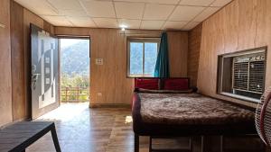 ein Schlafzimmer mit einem Bett in einem Zimmer mit einem Fenster in der Unterkunft Rishikesh Riverside Camping By PT in Rishikesh