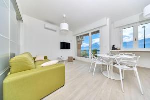 a living room with a yellow couch and a table at Benaco Hause 3 in Brenzone sul Garda
