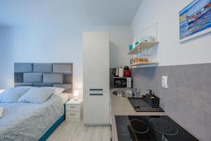 een kleine slaapkamer met een bed en een wastafel bij Guest House Arsenal Accommodation in Zadar