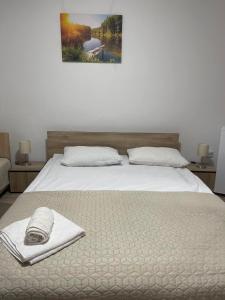 uma cama com um cobertor e uma toalha em The iNk Rooms em Ocna-Mureşului