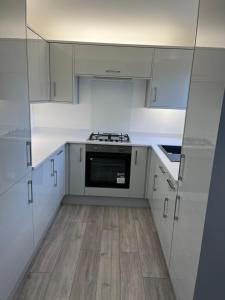 a kitchen with white cabinets and a stove top oven at Spectacular London Stay in Crystal Palace