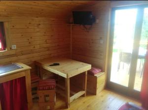 a wooden room with a wooden table in a cabin at Charmante roulotte in Collonges-lès-Premières