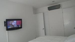 TV colgada en la pared de un dormitorio en Apartamento Los Morros, en Cartagena de Indias