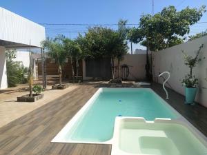 - une piscine dans un jardin avec une terrasse en bois dans l'établissement Piscina, Hidro, churrasqueira em casa, ambas privativas - Reserva 2 quartos com ar, 2 banheiros, sala,cozinha e pátio privativos, para moradia memorável ou evento, acesse descontão por duração!, à Sorriso
