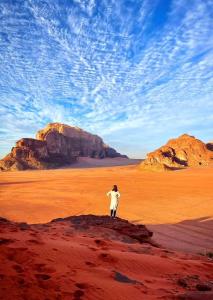 a person standing on a rock in the desert at Moon city camp in Wadi Rum